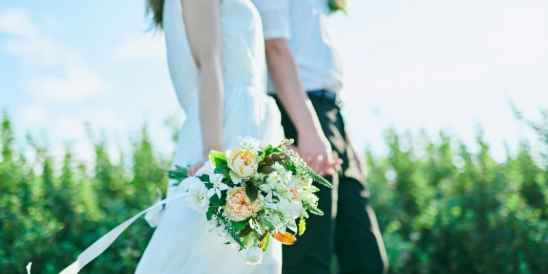 花束を持って歩く花嫁と花婿の写真