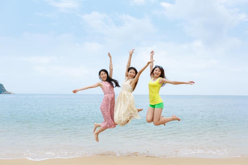 海辺でジャンプする女性3人