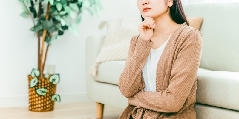 部屋で悩む女性の写真