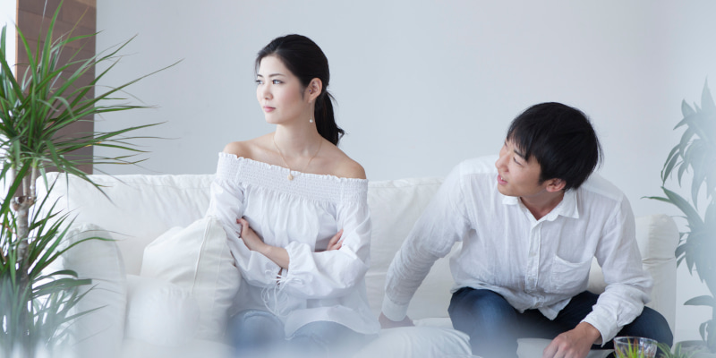 怒った彼女に弁明しようとする彼氏の写真
