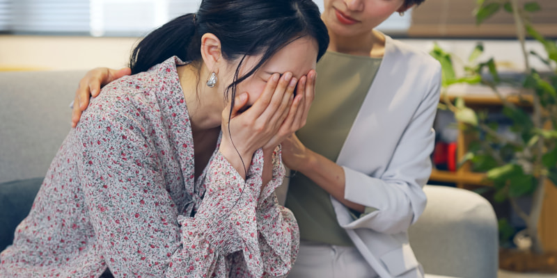 泣く女性を慰める女性の写真