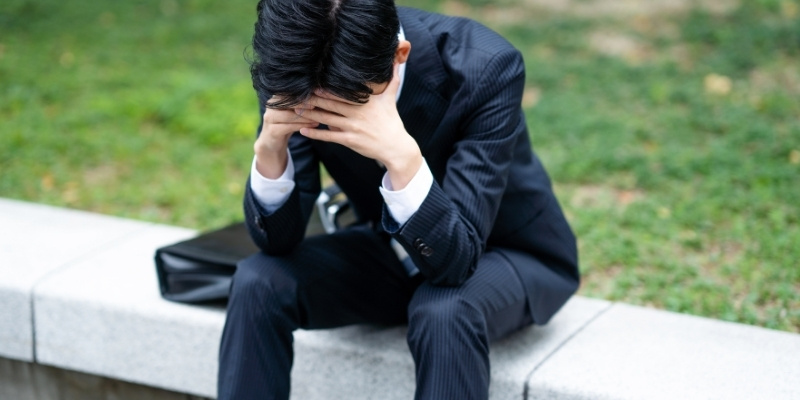 悩む若いビジネスマンの写真