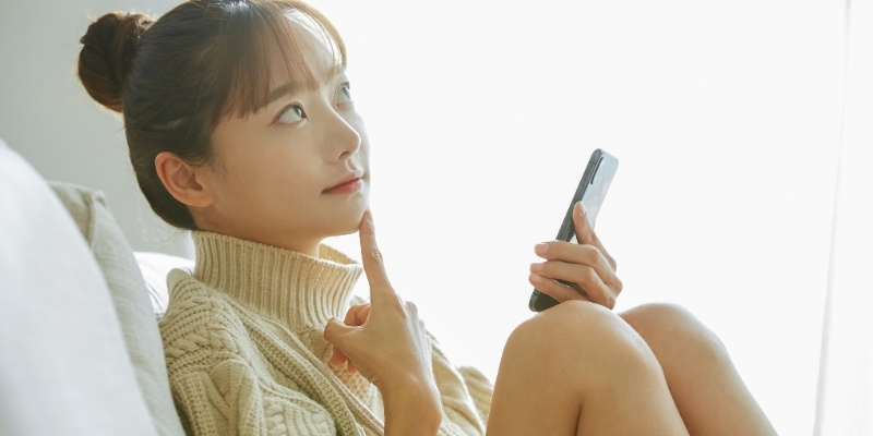 上目づかいで考える女性の写真