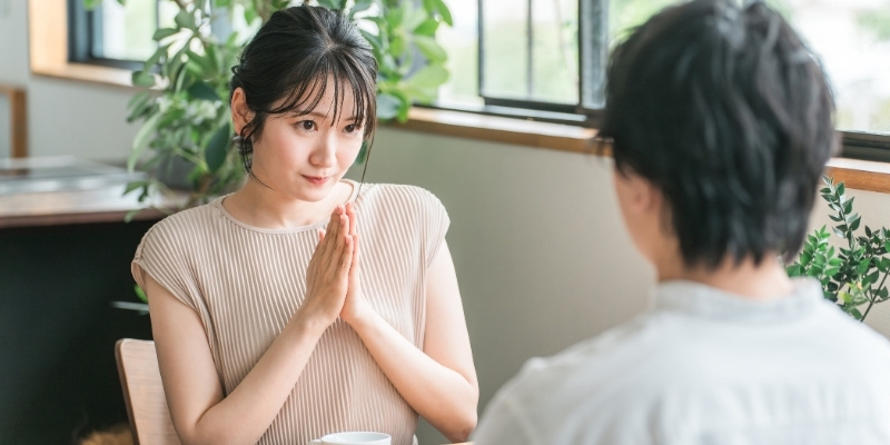 上目づかいでお願いする女性の写真