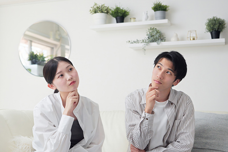 リビングで考え事をするカップル・夫婦