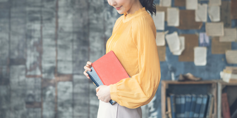 本を抱える女性の写真