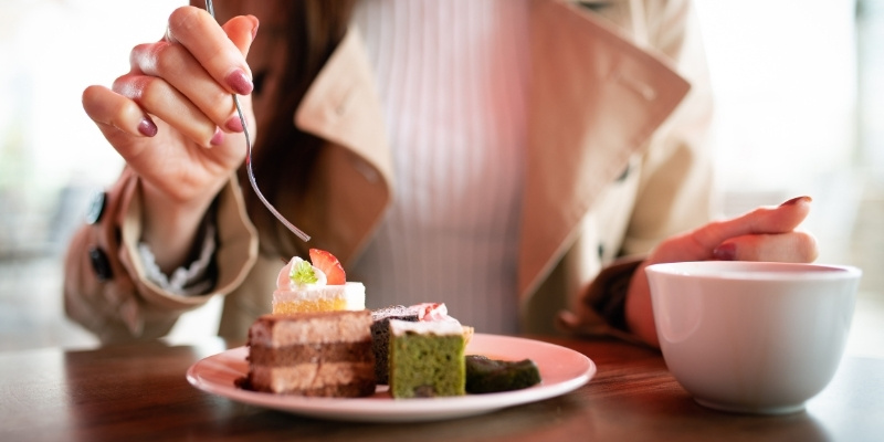 カフェで2つのケーキを食べている女性の写真