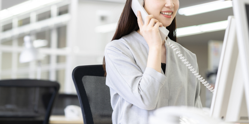 会社で電話する女性の写真