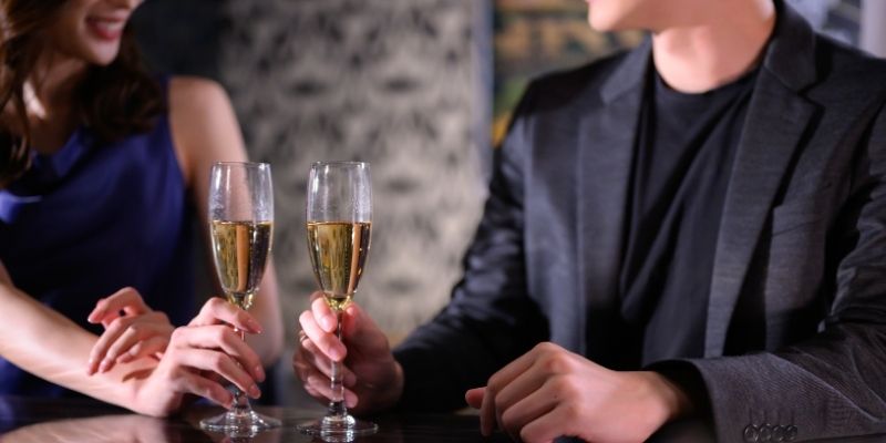 バーで飲む男女の写真