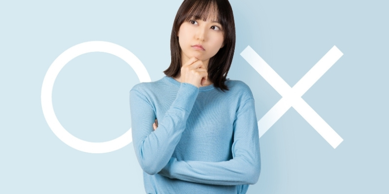 丸かバツかを考えている女性の写真