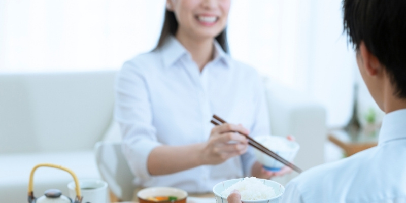 笑顔で朝食を食べている夫婦の写真