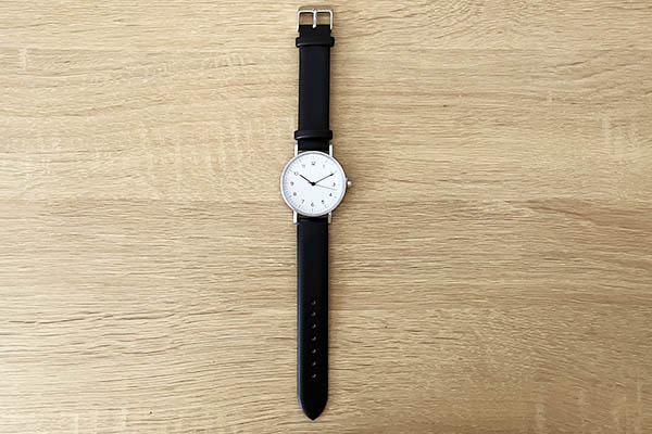 シンプルな腕時計が机に置いてある