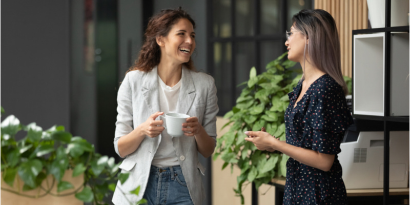 コーヒーカップを片手に談笑する二人の女性