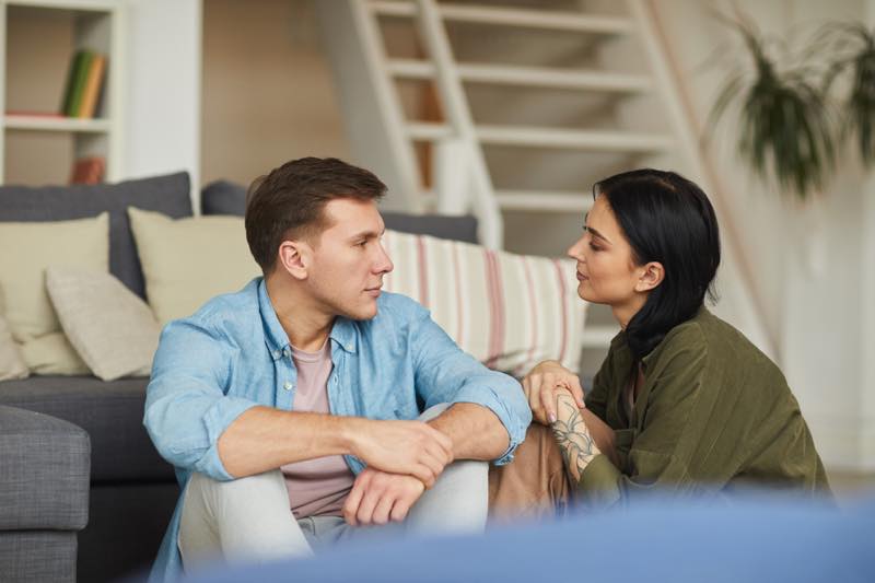 部屋で座って話し合っている男女