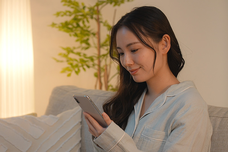 夜スマートフォンを見る女性