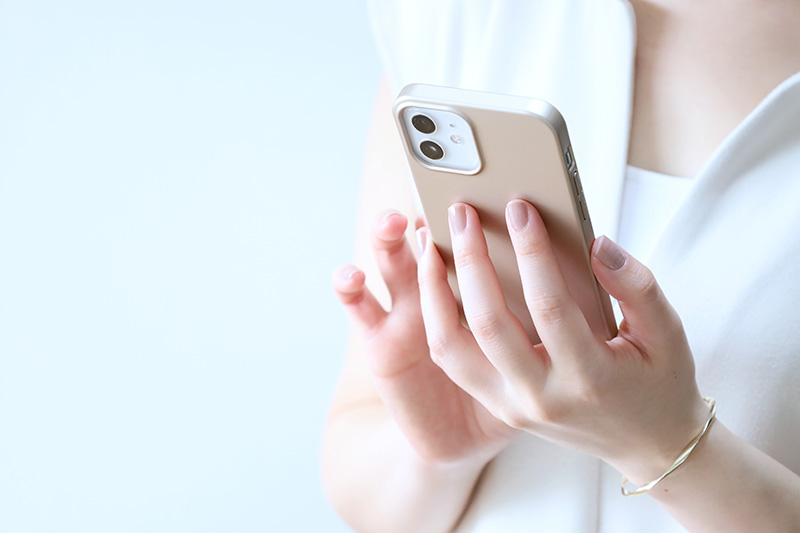 スマートフォンを見る女性の手元