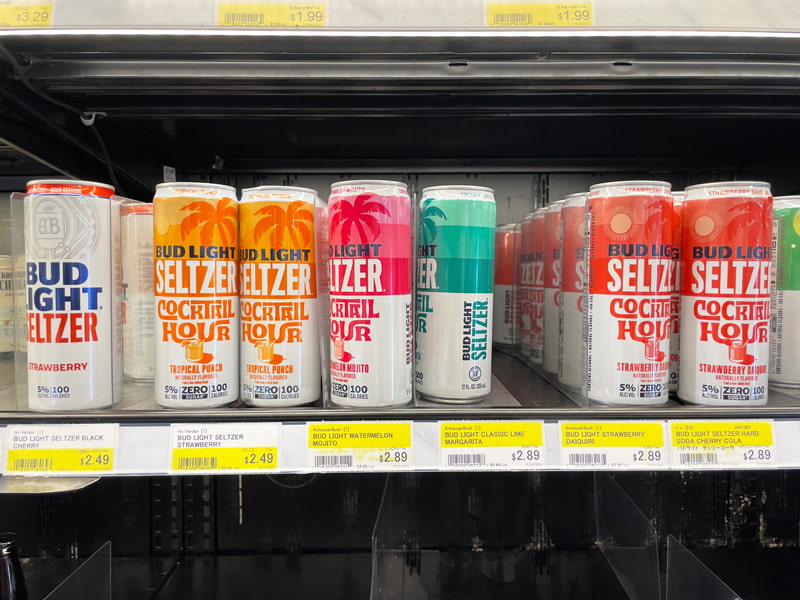 スーパーの冷蔵庫にアルコール缶が並べられている様子