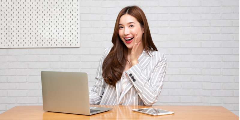 パソコンの前に座り笑顔で話す女性