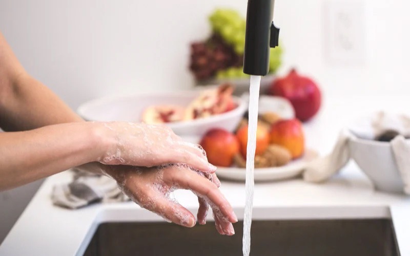 キッチンで手を洗う女性