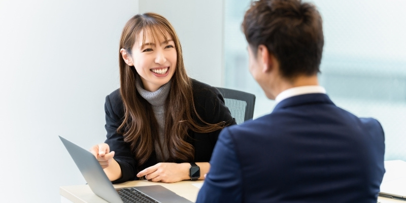 笑顔で話す男女のビジネスパーソンの写真