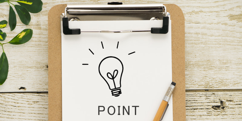 クリップボードに挟まれた紙に電球の絵とPOINTという文字が書かれた写真