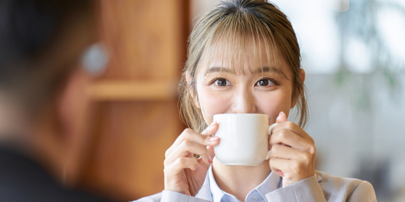 カフェで相手の目を見つめて話す女性の写真