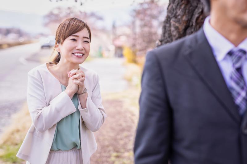 男性の背中に願う女性