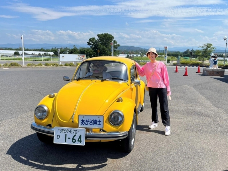 黄色い車の前に立つ徳島えりかアナ