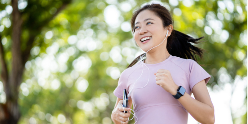 携帯で音楽を聴きながらジョギングする女性