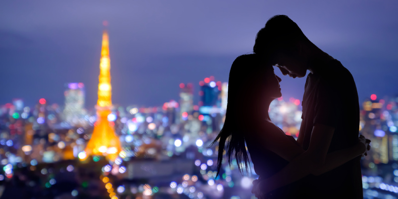 東京の夜景をバックに見つめ合う男女