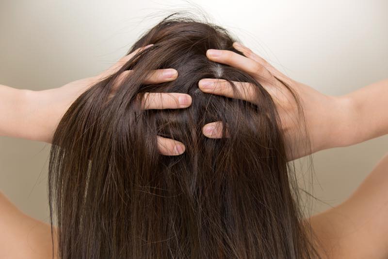 髪の毛に手を入れる女性の頭頂部