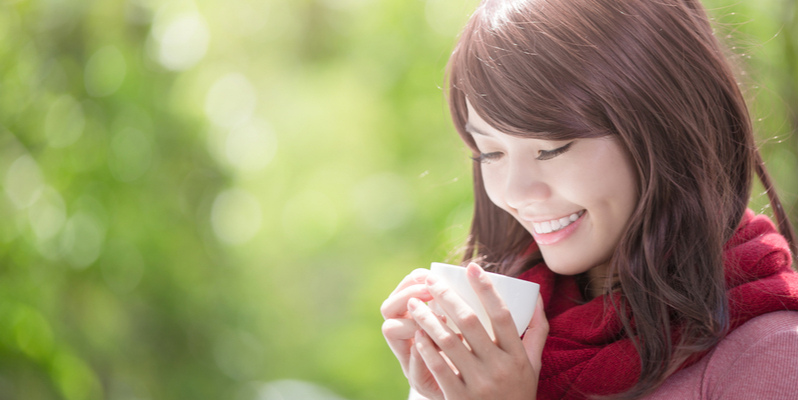 あたたかい飲み物をもつ女性