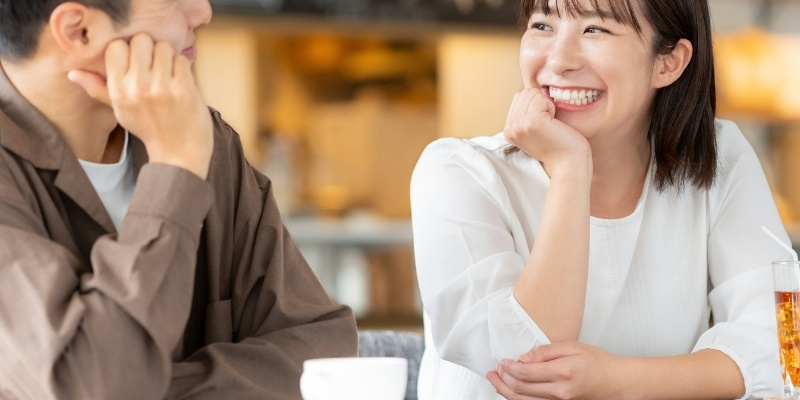 男性に笑顔で話しかける女性の写真