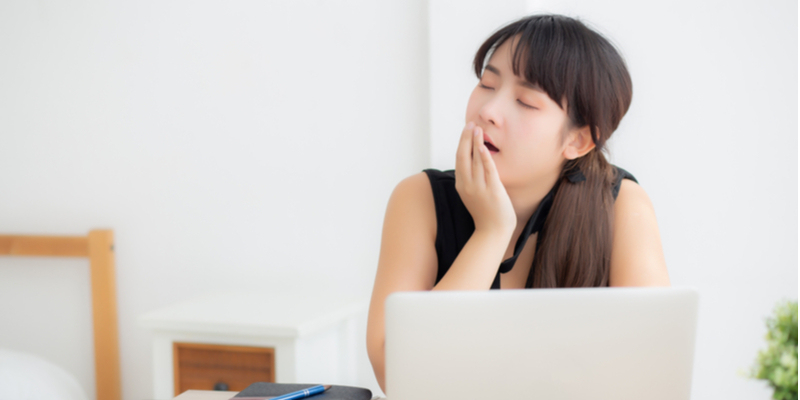 パソコンの前であくびをする女性