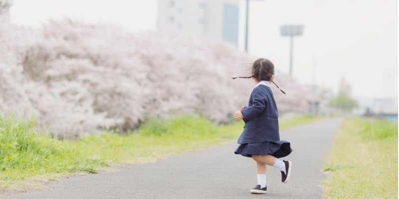桜並木を走る幼稚園児
