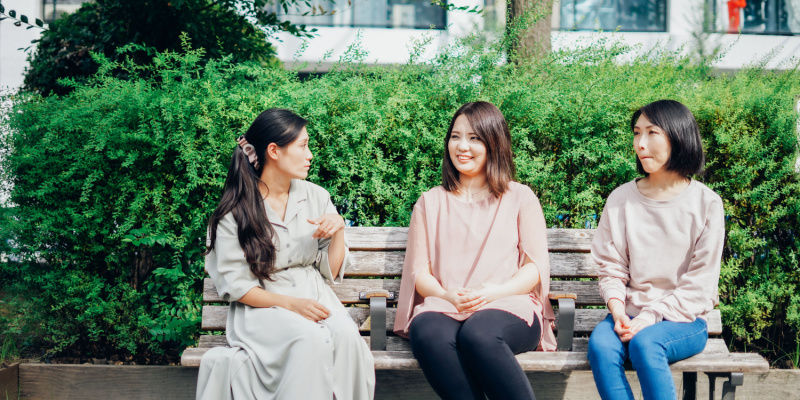 公園のベンチで会話する女性たち