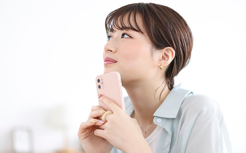スマホを持って考え事をする女性