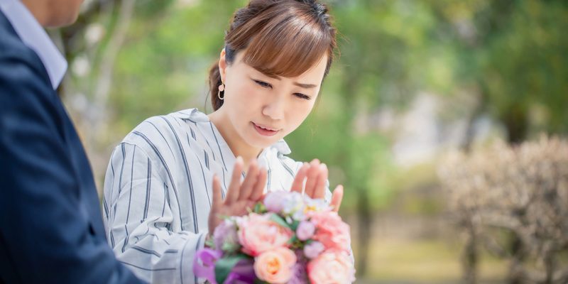 男性からの花束を断る女性