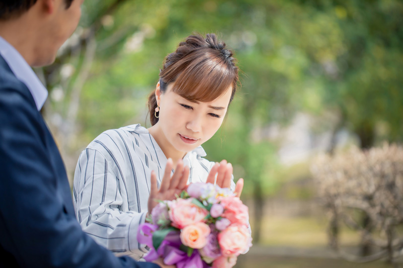 男性からの花束を断る女性