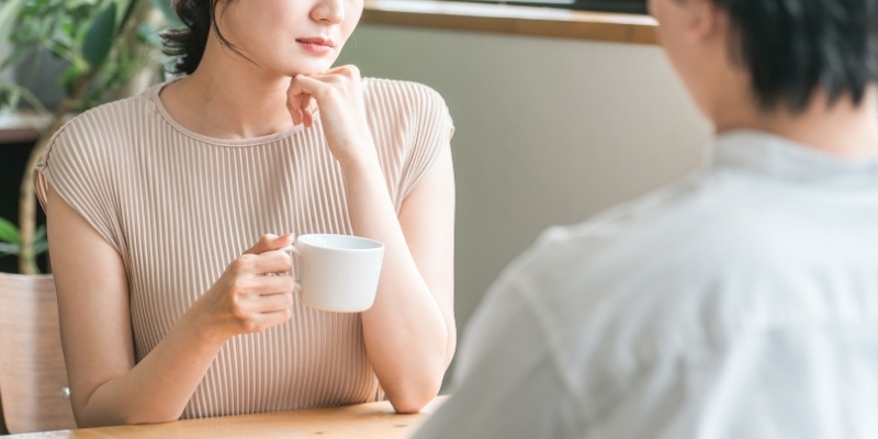 カフェで会話するカップル。不機嫌そうな彼女の写真