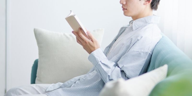 静かに本を読んでいる男性の写真