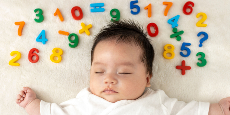 数字ブロックを頭の周りにおいて眠る赤ちゃん