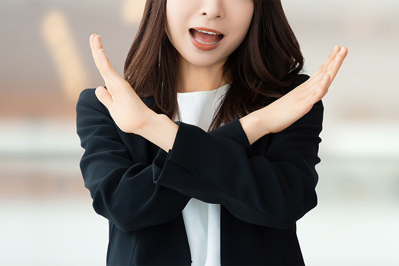 バツのポーズをする女性