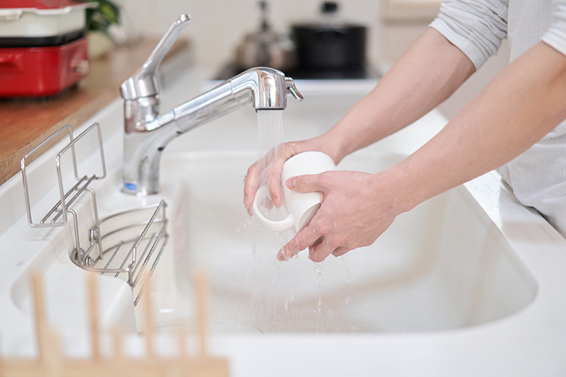 食器を洗う男性の手元