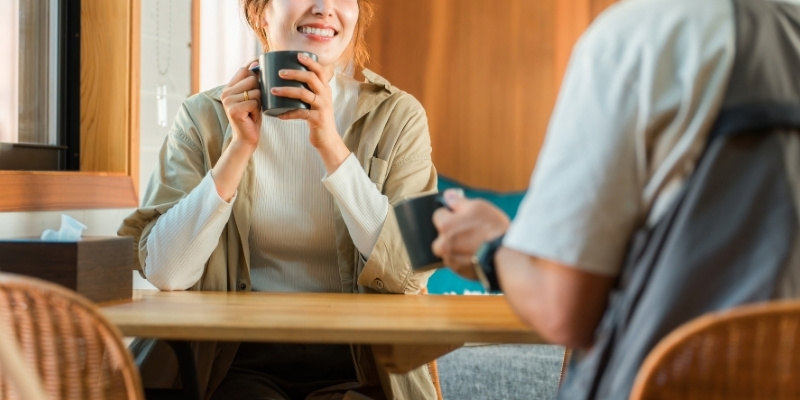 カフェで談笑する男女の写真