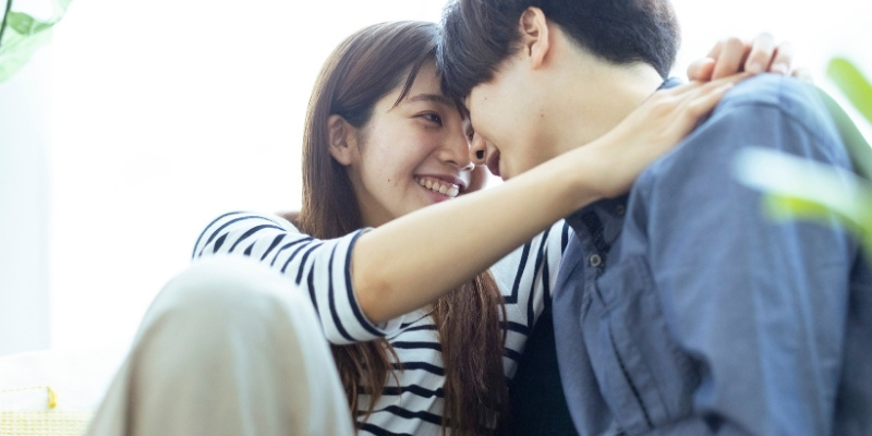 顔を寄せるカップルの写真