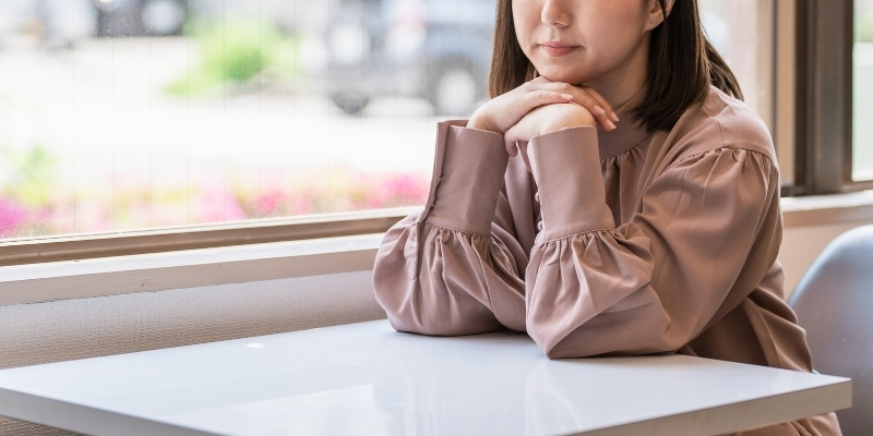 オフィスで考え事をしている女性の写真
