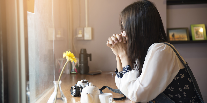 喫茶店で考え込む女性