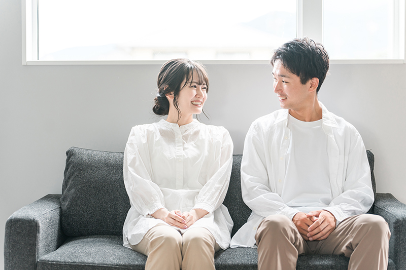 家のリビングのソファでくつろぐカップル・夫婦