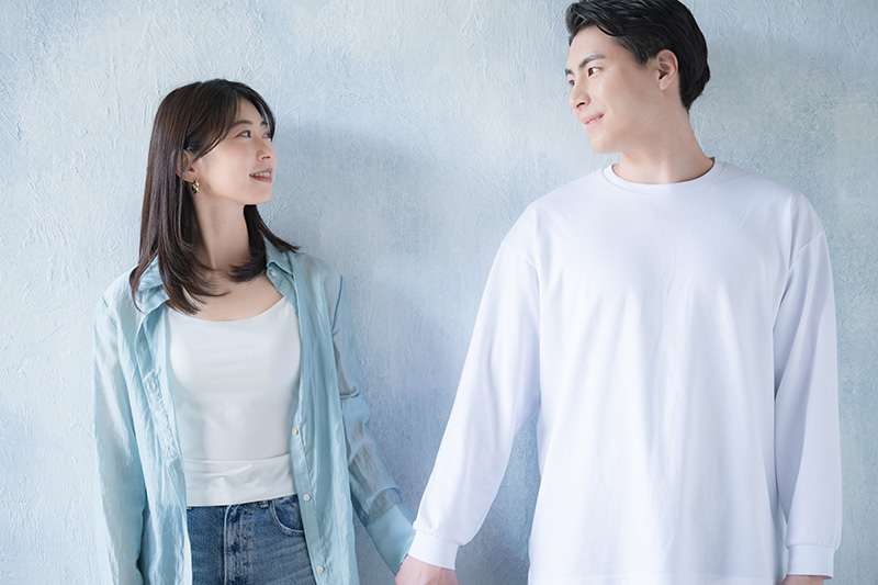 手を繋いで見つめ合うカップル